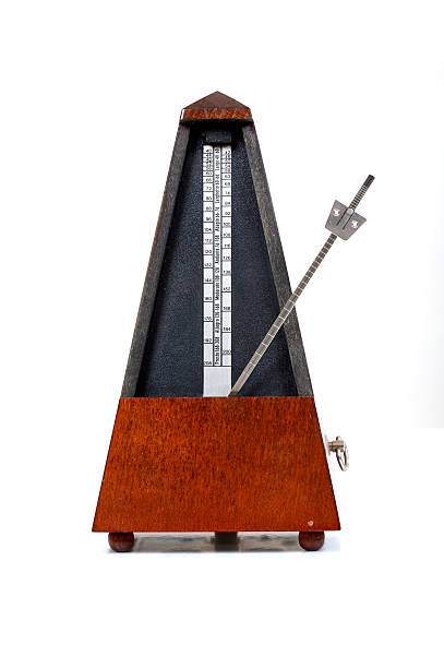 Metronome on white background A traditional mechanical metronome with a wooden base and black upper section, featuring a pendulum arm with adjustable weights for tempo markings.