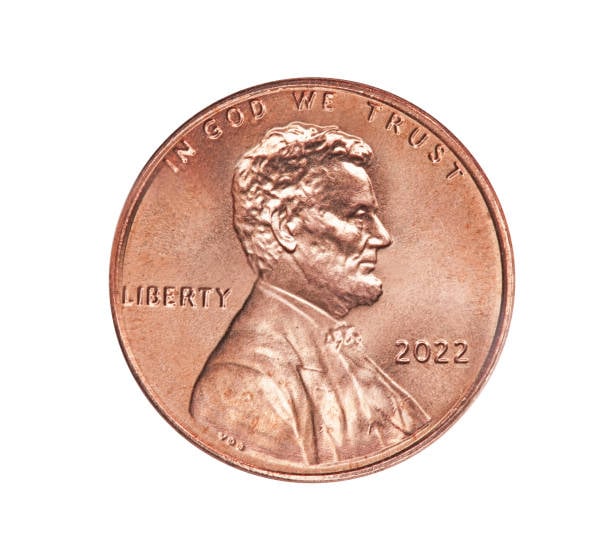 A 2022 US penny featuring Abraham Lincoln’s profile, the words “IN GOD WE TRUST,” “LIBERTY,” and the year, is displayed on a white background.