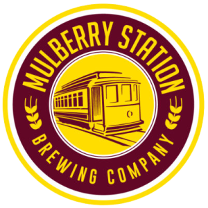 Circular logo for Mulberry Station Brewing Company featuring a vintage streetcar illustration in the center, with maroon and yellow colors and laurel accents.