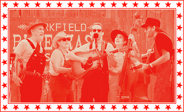 Five musicians in overalls perform with string instruments outdoors in front of a wooden backdrop, framed by a border of red stars.